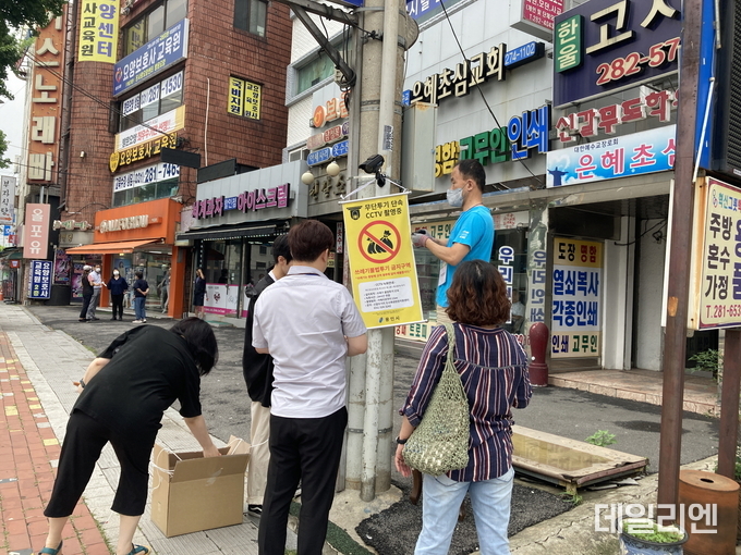 쓰레기 불법투기 문제 해결을 위해 모형 CCTV를 설치하고 있는 리빙랩 참여 시민들