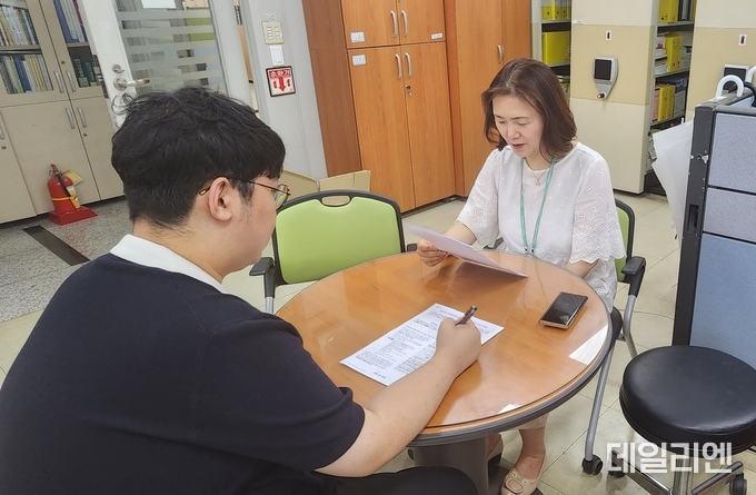 한 청년이 주거복지팀을 찾아 2023 청년·신혼 희망터치 보증금 이자지원 사업 참여 신청을 하고 있다.