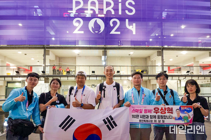 용인특례시 대표단과 파리 올림픽 결승 경기를 마친 우상혁 선수, 김도균 감독이 함께 기념촬영을 하고 있다
