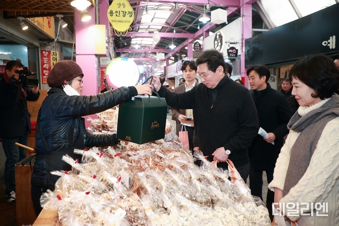 이상일 용인특례시장이 20일 부인 김미영 여사와 함께 용인중앙시장을 방문해 제수용품 등을 구입하며 장을 보고 있다.
