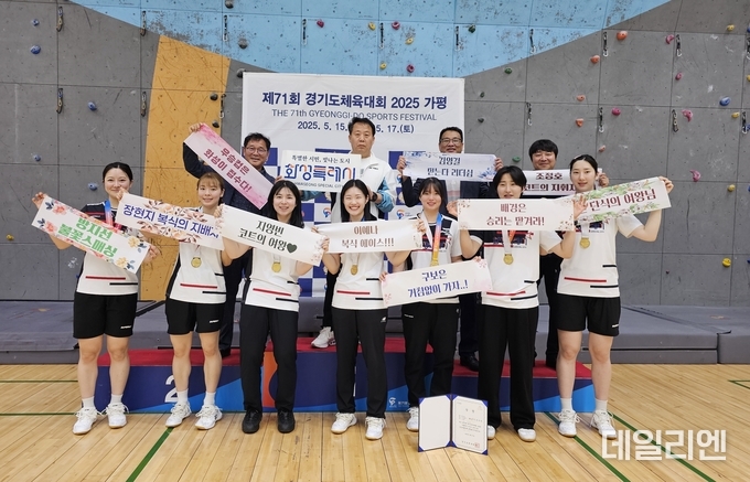제71회 경기도체육대회 여자 일반부 배드민턴에서 우승한 화성시 선수단이 금메달을 목에 걸고 기념촬영을 하고 있다. 선수들은 "복식의 지배자", "단식의 여왕님" 등 자신만의 구호가 담긴 플래카드를 들고 밝은 표정으로 우승의 기쁨을 만끽하고 있다.