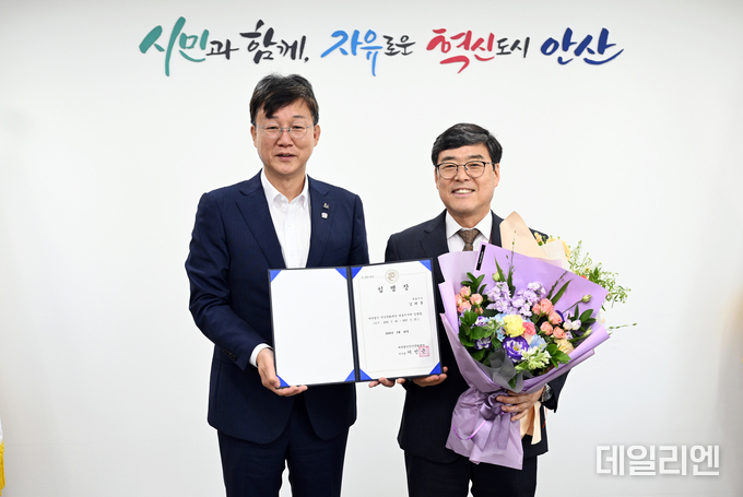 이민근 안산시장(왼쪽)이 김태훈 안산문화재단 신임 대표이사(오른쪽)에게 임명장을 수여하고 기념촬영을 하고 있다.