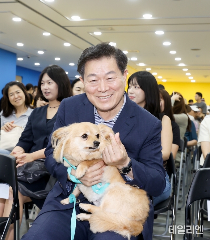 박승원 광명시장이 지난 13일 광명시민회관 전시실에서 열린 반려동물 전시회에 참석해 입양 당일 새 가족을 만난 유기견 '룽지'를 품에 안고 입양의 의미를 알리는 기념사진을 촬영하고 있다.