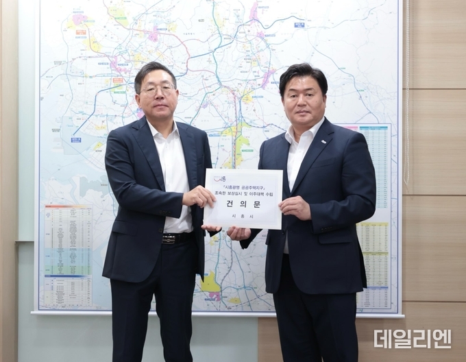임병택 시흥시장은 최용택 LH 광명시흥사업본부장(사진 왼쪽)에게 건의문을 전달하고 있다.
