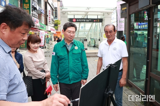  이상일 용인특례시장이 14일 수지구청역 버스정류장에서 노후차량 교체와 정류장 확장 계획을 보고받고 있다.