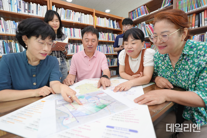 수원시 서둔동 주민들이 우리동네 자치계획을 들여다보며 회의를 하고 있다.