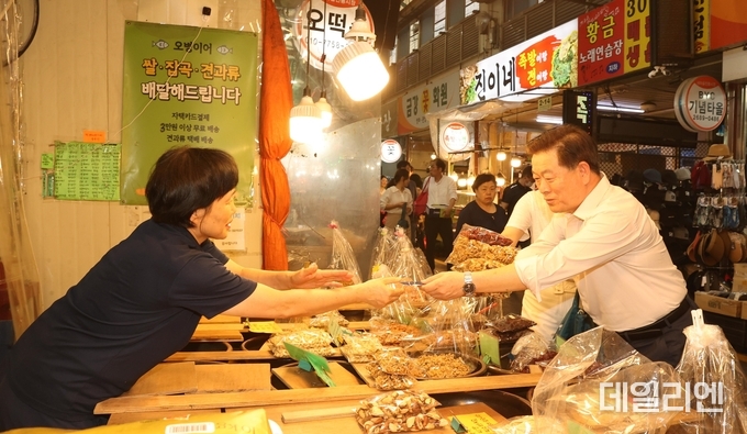 박승원 광명시장이 지난해 9월 추석 명절을 앞두고 새마을 전통시장을 찾아 광명사랑화폐로 상품을 구매하고 있다.