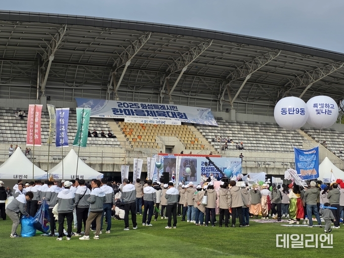 ‘2025 화성특례시민 한마음체육대회’ 개회식에서 읍면동 대표 선수단이 깃발을 들고 입장하며 개막을 축하하고 있다.