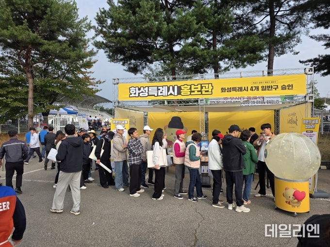 ‘2025 화성특례시민 한마음체육대회’ 행사장에 마련된 화성특례시 홍보관 앞에서 시민들이 이벤트에 참여하며 줄을 서 있다.