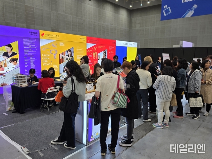 수원컨벤션센터에서 31일 개막한 ‘2025 뷰티썸 수원’ 전시장에서 관람객들이 수원여자대학교 부스에서 뷰티 관련 체험 프로그램에 참여하고 있다.