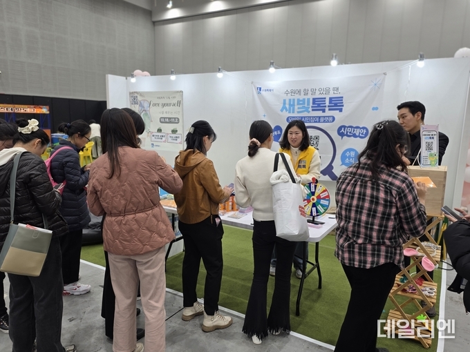 ‘뷰티썸 수원 2025’ 박람회에서 시민들이 수원시가 운영하는 ‘새빛톡톡’ 부스를 방문해 참여 이벤트에 참여하고 있다.