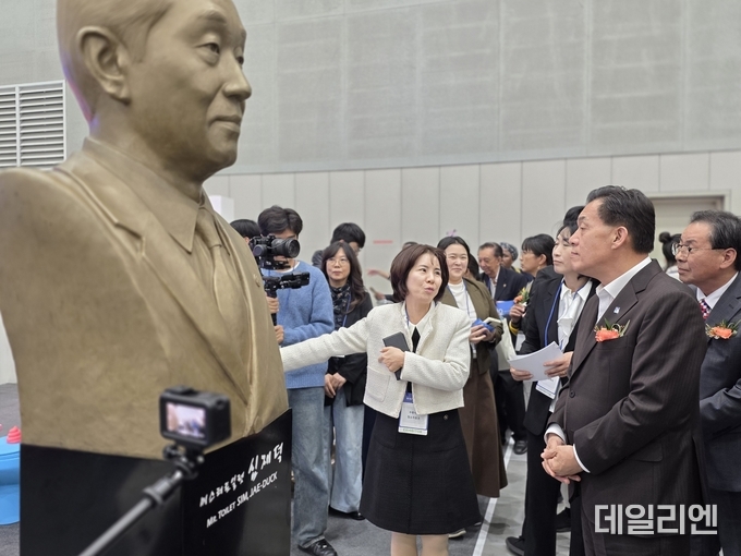 ‘뷰티썸 수원 2025’ 개막식 후 이재준 수원특례시장이 화장실문화운동 창시자 고 심재덕 전 수원시장의 흉상이 설치된 해우제 부스에서 관계자의 설명을 듣고 있다.