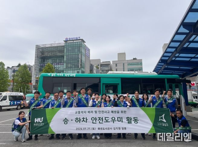 향남환승버스터미널에서 승하차 안전 도우미 활동에 참여하는 화성도시공사 임직원들이 단체 사진을 찍고 있다.(화성도시공사 제공)