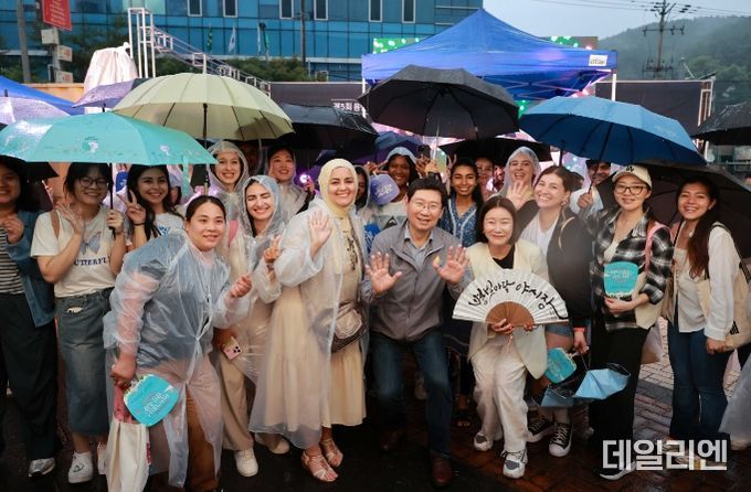 이상일 용인특례시장이 지난달 29일 용인중앙시장 별빛마당 야시장 개장식에서 시민, 외국 SNS인플루언서, 관광객과 기념 촬영을 하고 있다.