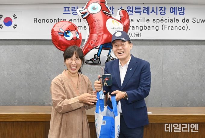 이재준 수원시장이 선물을 주고 받으며 환하게 웃고 있다.
