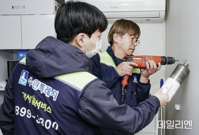 가사홈서비스 기술자가 선반을 설치하고 있다