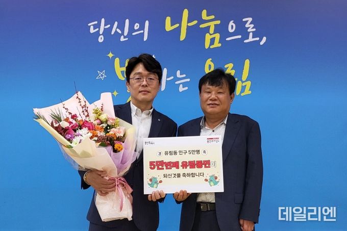 지난달 28일 처인구 유림동의 5만번째 주민이 된 권병손씨(왼쪽)가 기념촬영을 하고 있다.