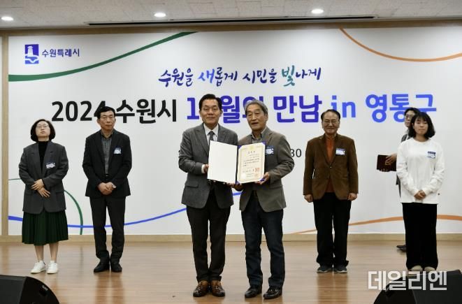 이재준 수원시장(왼쪽)과 송재등 전 매탄3동 주민자치회장이 표창장 전수 후 함께 하고 있다.