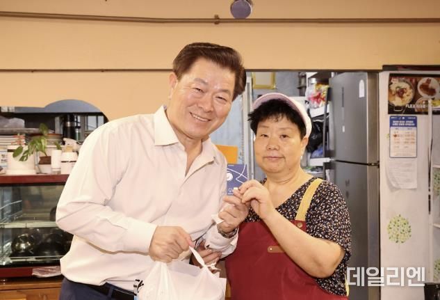 박승원 광명시장이 지난 9월 '추석명절 물가안정 대비 전통시장 물가체험'으로 광명전통시장을 방문해 상품 구입 후 상인과 광명사랑화폐 카드를 들고 기념사진을 촬영하는 모습